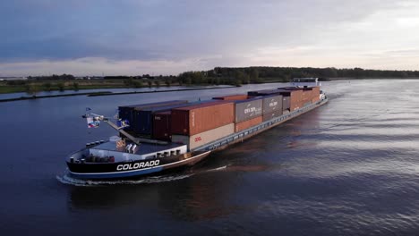 Colorado-Schiff-Beladen-Mit-Containern,-Die-Waren-Bei-Sonnenuntergang-In-Barendrecht,-Niederlande,-Transportieren