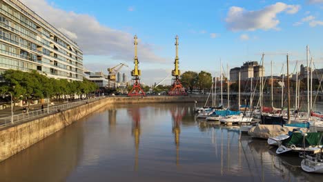 Low-forward-aerial-of-boats-in-marina-and-port-cranes-in-Buenos-Aires