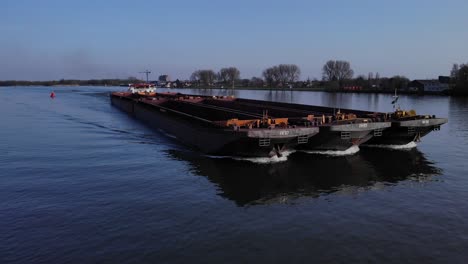 Pushtow-With-Six-Cargo-Barge-Passing-By-At-The-Town-Of-Puttershoek-In-Netherlands-Through-The-River-Oude-Maas