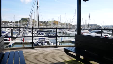 Luxury-sailboats-and-yachts-moored-Conwy-marina-shaded-seating-waterfront-North-Wales-slow-left-dolly