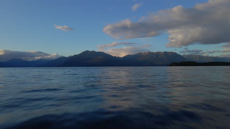 Fliegen-über-Der-Wasseroberfläche-Am-Lake-Te-Anau-Mit-Bergen-Im-Hintergrund
