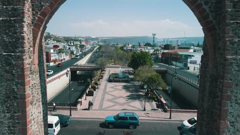 Vista-Aerea-Del-Drone-Pasando-Por-Los-Arcos-De-Queretaro-Al-Mediodia