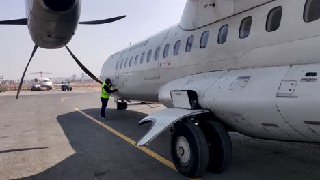 El-Personal-De-Tierra-Examina-La-Puerta-De-Carga-De-Un-Avión-Turbohélice-Estacionado-En-La-Plataforma