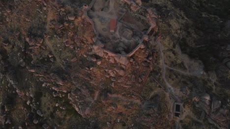 Monsanto-castle-ruins-at-sunrise,-Portugal.Aerial-top-down-forward
