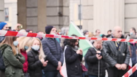 Cinta-De-Barricada-Roja-Y-Blanca-Con-Manifestantes-En-Segundo-Plano-En-Piazza-Xxv-Abril-En-Medio-De-Una-Pandemia-En-Milán,-Italia