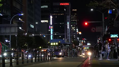 Pedestrians-cross-a-busy-street-in-downtown-Seoul,-South-Korea-near-the-Gangnam-Bus-Station---slow-motion-at-night