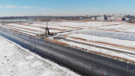 Patinadores-Sobre-Hielo-En-El-Canal-Holandés-Congelado,-Vista-Aérea-De-Invierno-De-4k