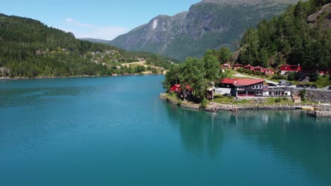 Loenvatn-See-Ferienzentrum-An-Einem-Hellen-Sommertag-–-Sich-Nähernde-Luftaufnahmen-Zeigen-Glückliche-Menschen,-Die-Im-Gletschergrünen-Süßwassersee-Schwimmen-Und-SUP-Paddleboard-Benutzen-–-Loen,-Norwegen