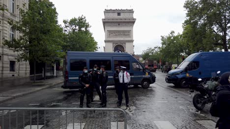 Aufnahme-Von-Polizisten,-Die-Während-Des-Nationalen-Bastille-Tages-Vor-Ihrem-Lastwagen-Stehen,-Mit-Dem-Arc-De-Triomphe-Im-Hintergrund,-Paris,-Frankreich
