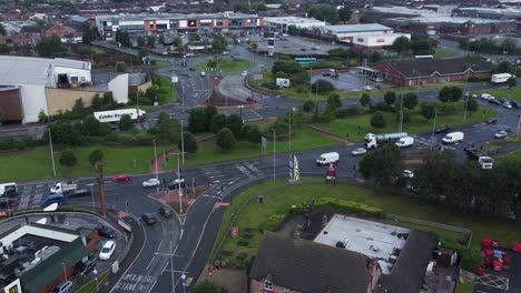 Aerial-view-above-busy-British-shopping-retail-car-park-store-shops-orbit-right-above-traffic