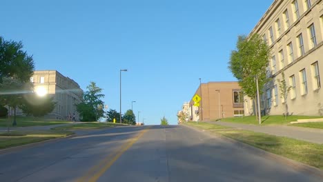 POV-while-driving-on-Washington-Street-thru-the-University-of-Iowa-Campus,-past-the-Pentacrest,-Seamans-Center,-MacLean-Hall-and-Schaeffer-Hall-on-a-sunny-summer-afternoon