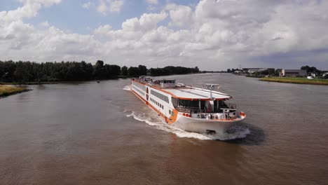 Aerial-Flying-Across-Bow-Of-MS-Vistastar-River-Cruise-Ship-On-River-Noord