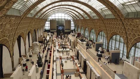 Orsay-museum-principal-gallery-with-statues-and-visitors-and-tall-glass-ceiling