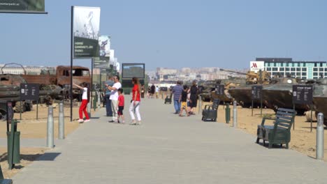 Familias-Azerbaiyanas-Disfrutan-De-Las-Exhibiciones-En-Un-Día-Soleado-En-El-Parque-De-Trofeos,-Baku,-Azerbaiyán