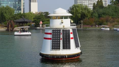 Water-quality-measurement-buoy-with-solar-panels-floating-on-lake-in-Songdo-Central-Park,-Incheon-South-Korea
