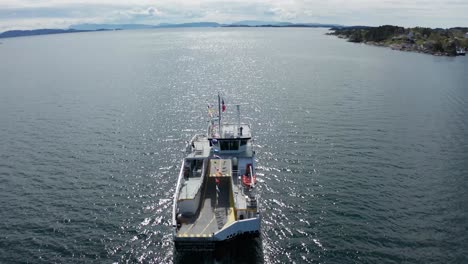 Flying-over-tilting-down-to-birds-eye-of-Norway-ferry-with-ships-dressing-flagging