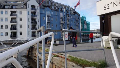 Walking-along-waterfront-in-the-harbor-of-Alesund,-Norway