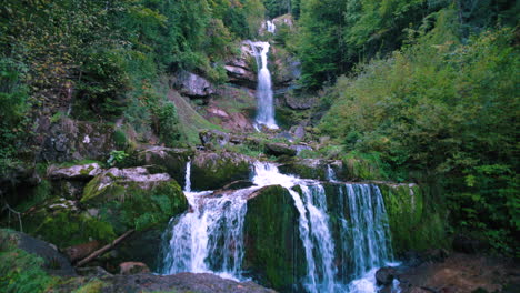 Moody-Giessbach-waterfall-view-at-morning,-splashing-on-rocks-inside-lush-green-forest-in-Brienz-Switzerland,-Europe