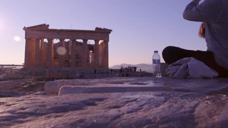 Un-Turista-Bebe-Una-Botella-De-Agua-Al-Atardecer-Cerca-Del-Partenón