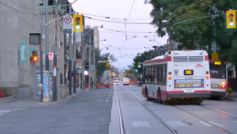 Busse-Auf-Der-Stadtstraße-Mit-Straßenbahn-In-Toronto,-Kanada-Tagsüber