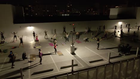 Night-aerial-of-headphones-Zumba-class-on-Miami-roof-top-parking-lot