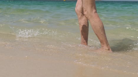 Slow-motion,-old-man's-legs-with-varicose-veins-walking-on-beach-sea-shore