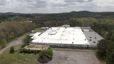 Aerial-Drone-Footage-Pulling-Away-from-an-Abandoned,-Decaying-National-Standard-Factory