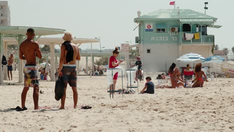 El-Punk-Descarado-Conduce-Agresivamente-En-Una-Moto-De-Tierra-Entre-Las-Personas-Inocentes-En-Una-Playa-Israelí-En-Ashkelon-Saludando-A-Su-Amigo