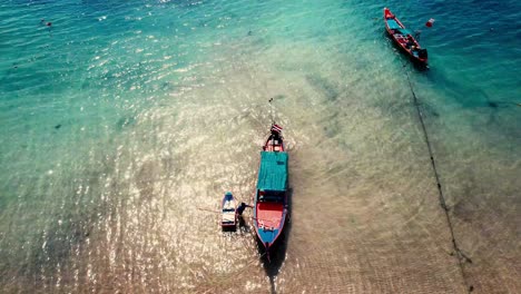 Eine-Drohnenaufnahme-Eines-Longtail-Bootes,-Das-In-Der-Nähe-Des-Strandes-Von-Koh-Tao-Festgemacht-Hat
