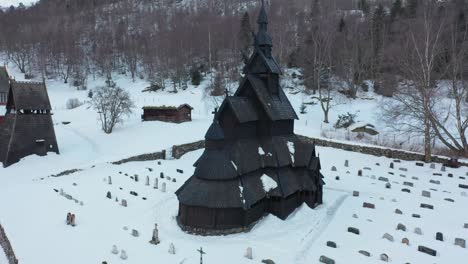 órbita-Alrededor-De-La-Iglesia-De-Madera-De-Borgund-De-La-Era-Vikinga-En-Noruega---Antena-De-Invierno-Con-Iglesia-En-El-Centro-Y-Paisaje-Nevado