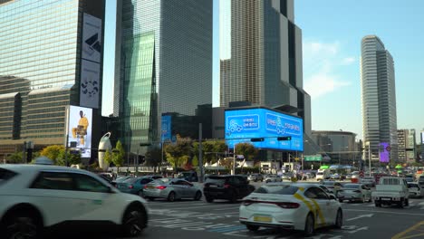 World-Trade-Center-Seoul---Autoverkehr,-Der-An-Der-Kreuzung-Der-U-Bahn-Station-Samseong-Auf-Der-Breitesten-Mehrspurigen-Straße-In-Der-Nähe-Des-Coex-Trade-Tower-Und-Des-Parnas-Tower-Bei-Sonnenuntergang-Im-Herbst-Vorbeifährt