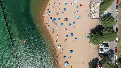 Colorful-Kayaks-And-Parasols-On-Sandy-Beach-In-Summer