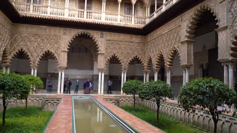 Left-to-right-pan-insisde-famous-Alcazar-in-Seville,-Spain-with-few-people