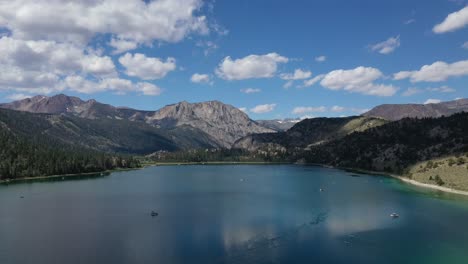Mountain-Lake-Against-Blue-Cloudy-Sky-In-June-Lake-California,-USA---aerial-pullback
