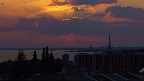 Time-Lapse-of-sun-set-over-the-sea-with-a-harbor-and-a-city