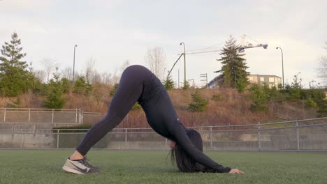 Mujer-Atlética-Realiza-Estiramiento-De-Yoga-De-Perro-Boca-Abajo
