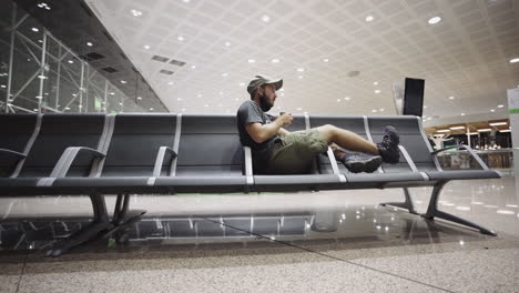 Unbequemer-Flughafen-Gate-Stuhl-Für-Einen-Jungen,-Kaukasischen,-Modernen-Touristen