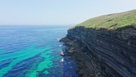 Large-rocky-cliffs-stratified-on-turquoise-sea-water-shore-of-northern-Spain
