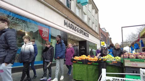 Gente-Pasando-Por-Un-Puesto-En-El-Mercado-De-Frutas-Y-Verduras-Fuera-De-Marks-Y-Spencer-St-Albans