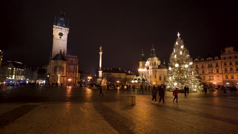 Gente-Caminando-Por-La-Plaza-Del-Casco-Antiguo-Con-árbol-De-Navidad,-Praga-Nocturna