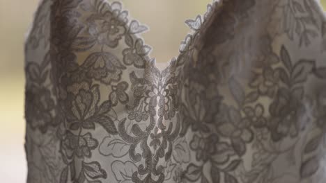 Close-up-details-of-the-chest-of-a-glamourous-wedding-gown-hanging-outside-on-a-fall-day