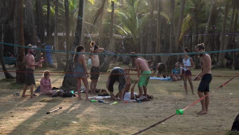 Men-and-women-playing-Chinese-Yoyo,-juggling-balls-and-stretching-at-a-Tribal-Gathering-encampment,-Handheld-medium-shot