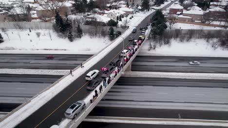 Órbita-Aérea-De-Los-Manifestantes-De-La-Manifestación-De-La-Libertad-De-Pie-A-Lo-Largo-Del-Borde-Del-Puente-De-La-Autopista-401