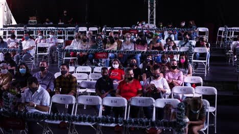 audience-seated-in-an-indoor-theater-with-a-mask-waiting-for-a-theater-show