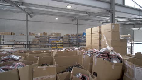 Solar-panel-warehouse-with-boxes-and-containers-of-gear-and-installation-materials,-Dolly-right-shot