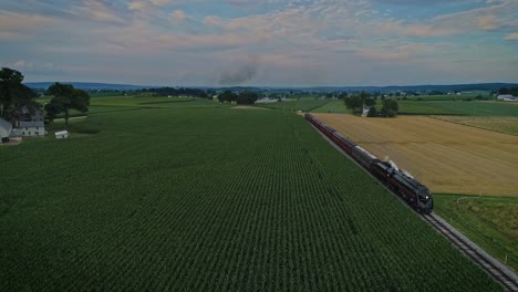 Una-Vista-Aérea-De-Un-Antiguo-Tren-De-Pasajeros-De-Vapor-Que-Sopla-Humo-A-Través-De-Las-Tierras-Agrícolas-De-Pensilvania