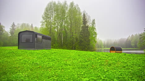 Static-shot-of-wooden-cabin-and-a-barrel-sauna-during-rainy-season-at-daytime