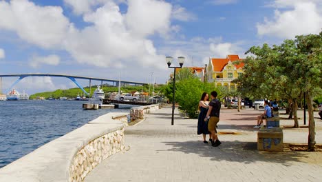 Young-couple-taking-a-selfie-near-the-Queen-Juliana-Bridge-in-Saint-Anna-Bay,-Willemstad,-on-the-Caribbean-island-of-Curacao