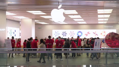 Kunden-Gehen-In-Einem-Einkaufszentrum-In-Hongkong-Am-Offiziellen-Apple-Store-Und-Logo-Der-Multinationalen-Amerikanischen-Technologiemarke-Vorbei