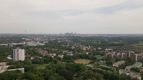 Aerial-approach-towards-the-cityscape-of-Frankfurt,-Germany-on-an-overcast-spring-day